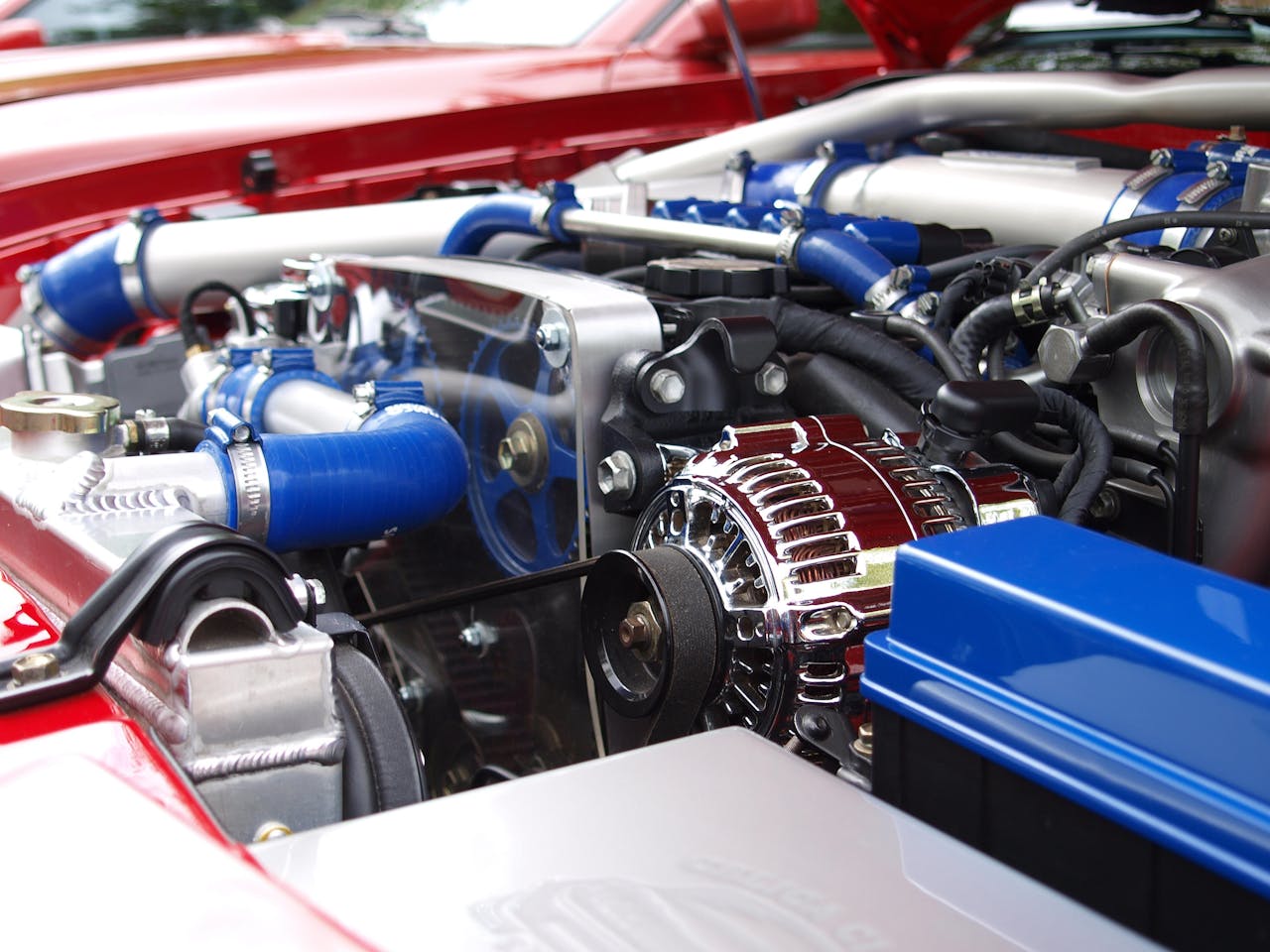 Detailed view of a clean modern car engine with vibrant colored components and sleek design.